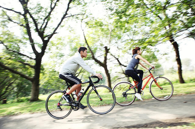 脂質異常症改善の運動療法の例としてサイクリングをしている男女の写真。