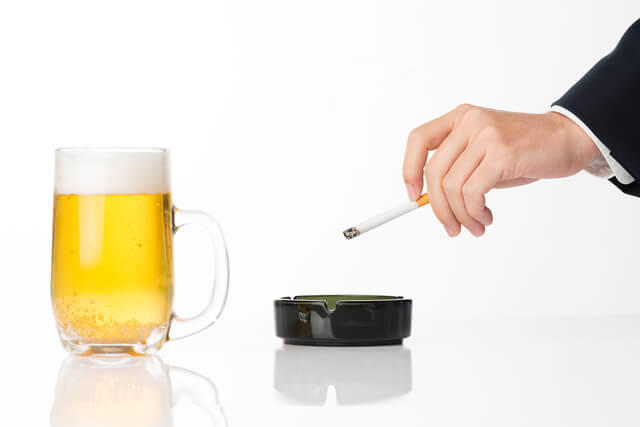 ジョッキに入ったビールとタバコの写真。禁煙と適正飲酒の推奨を示す。