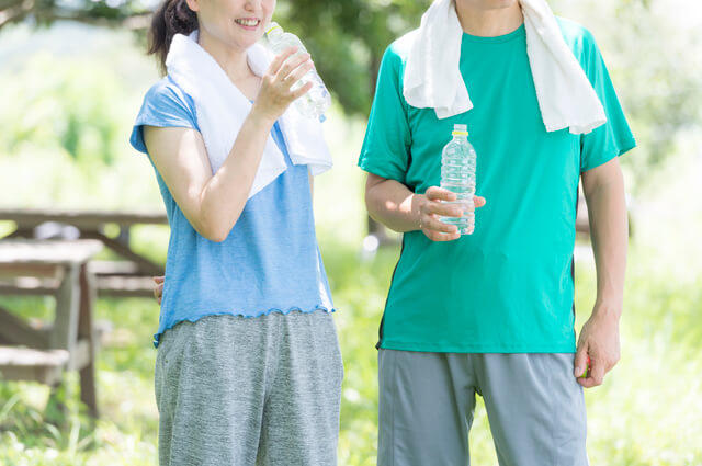 運動後にペットボトルの水を飲む男女の写真。適度な運動は内臓機能を回復させて鉄分の吸収を高め、赤血球の生産を活発にする作用があり貧血の予防になる。