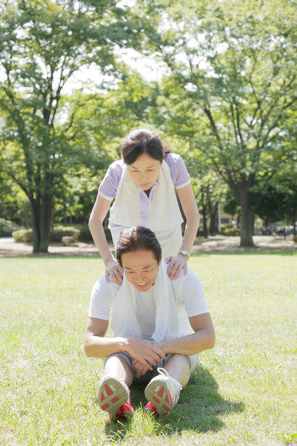 準備運動を行う高齢夫婦の写真。ウォーミングアップとは「運動によるケガの防止や、主運動を行うための身体の準備、その運動に対する能力を最大に発揮できる状態をつくること」を目的に行う、運動前の準備運動を意味します。ウォーミングアップを行うことで、体温を上昇させる、心拍数と呼吸数を徐々に増加させるなどといった効果があります。
