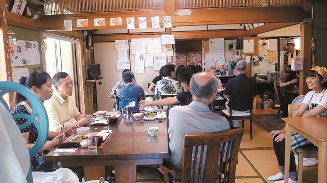 写真3:みちくさ亭で介護家族、認知症の本人、地域の人が集まって息抜きや会話を楽しむ様子を表わす写真。