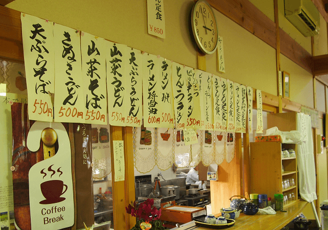 写真3:郷土食など地元の新鮮な食材を活かし、食堂内に様々なメニューが並べられている様子を表す写真。時期に合わせメニューも変えられ、旬のものを楽しんでもらう工夫がされている。