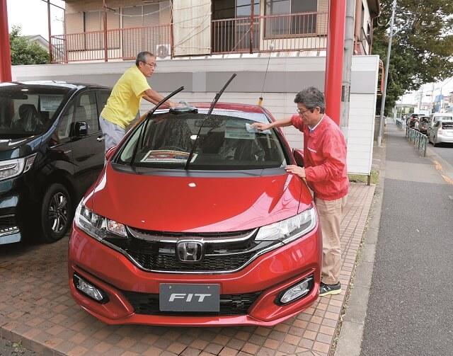 写真4:有償ボランティアとしての仕事のひとつである洗車の様子を表す写真。数人でチームとなり仕事に取り組む。