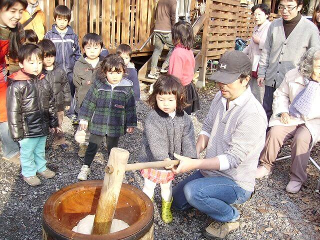 写真8:施設で行う正月恒例の餅つきの様子を表す写真。近隣の人や通りすがりの人も参加する。