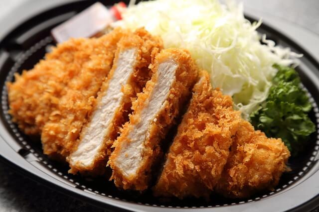 主菜3つ(SV)のとんかつの写真。主菜の1日の摂取基準量は、摂取カロリーにより異なる。主菜はメニューより脂質が多くなるので調理方法に気を付け様々な食品から主菜を補うようにすることが大切。