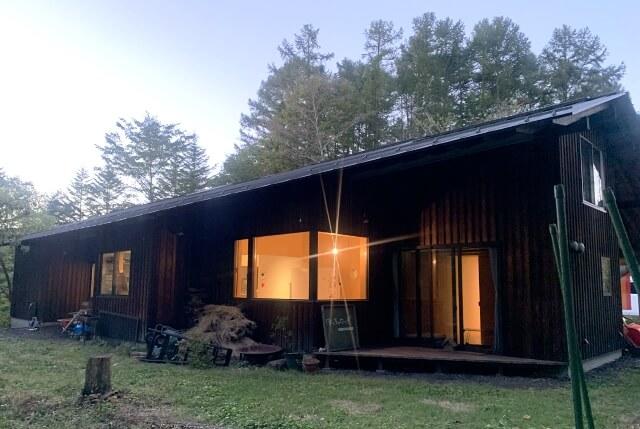 森に囲まれたほっちのロッヂの外観を表す写真。