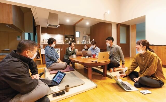 大きな台所の前の座卓で多職種ミーティングをしている写真。