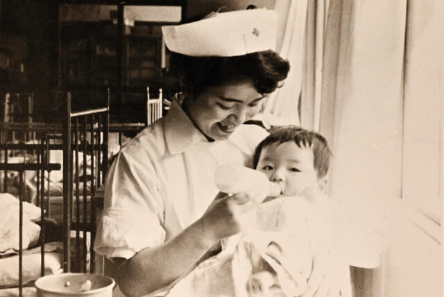 かわしま氏が病棟の赤ちゃんにミルクを与えている写真。