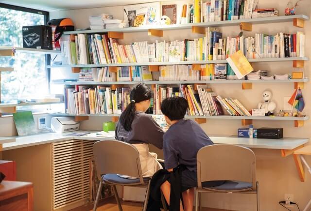 緩やかに仕切られた文庫で読書をしている子どもたちの写真。