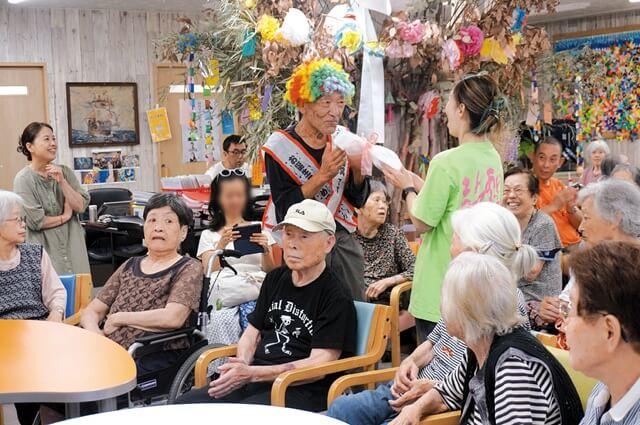 お茶会の中で、誕生日を迎えた入居者をみんなで祝っている写真。