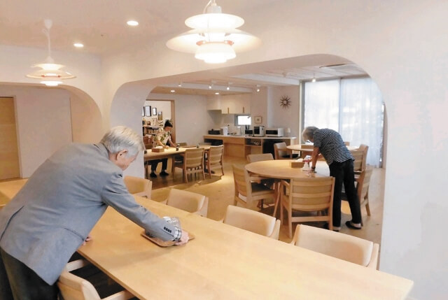 テーブル拭きを行う入居者の写真。
