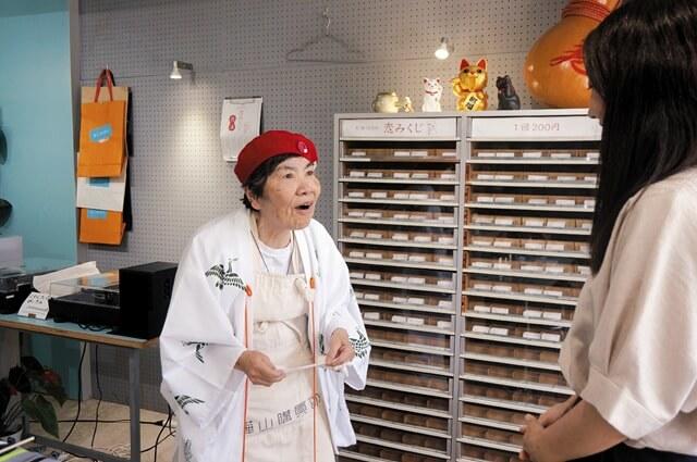 「大吉よ!」と 恋みくじを読む公子さんの写真。