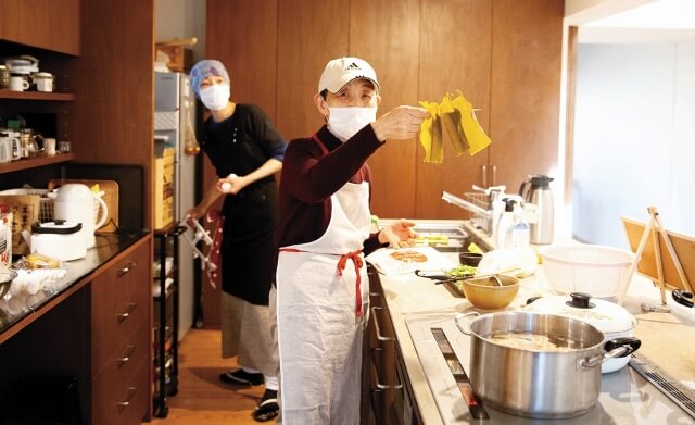 ボランティアやパートスタッフである地域の人が調理をしている写真。