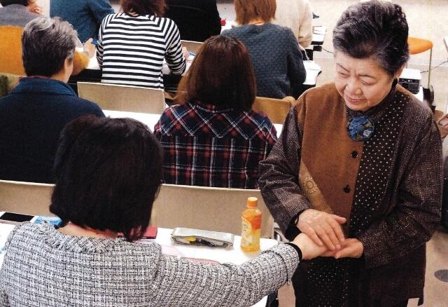 東日本大震災被災地のて・あーて塾で手を使ったケアを実技指導している写真。