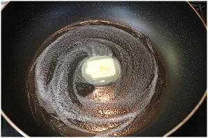 写真：フライパンにバターを入れ、溶かす様子を表す写真。