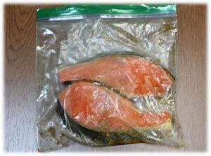 写真：鮭の下味をつける工程を表す写真。