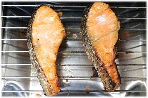 写真：鮭を魚焼きグリルで焼く様子を表わす写真。