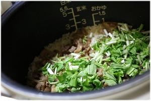 写真：炊きあがったご飯に水菜を入れる様子を表わす写真。