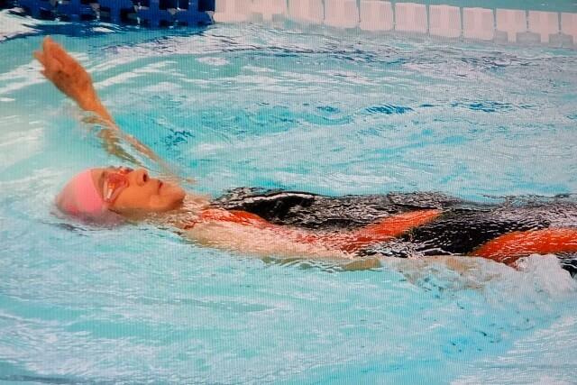 写真1：長岡さんが背泳ぎをしている様子を表す写真。