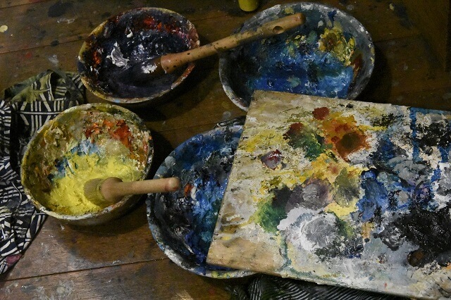 写真3：野見山さんが愛用する絵筆とパレットと溶き皿の写真。