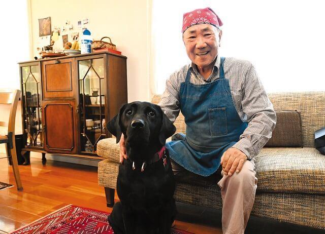 愛犬ヴァトンとともに笑顔のまさるさんの写真。