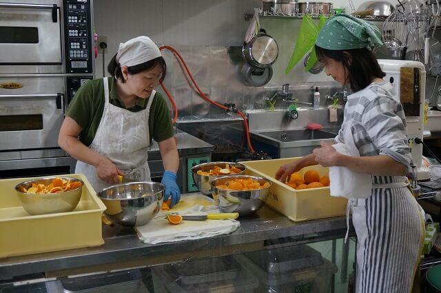 写真6：お菓子工房「バレンシア畑」の厨房で調理する様子を表す写真。