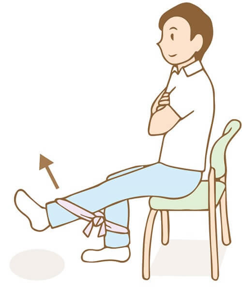 図1：椅子に座った姿勢でフィットネスバンドを使い膝を伸ばす運動をする様子を表す図。