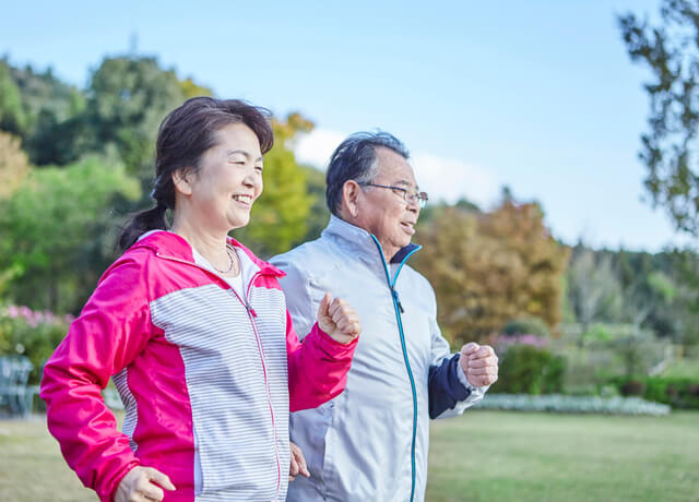 高齢者夫婦がウォーキングを行っている写真。生活の質（QOL）を高めるには、身体的・精神的な健康を維持することが重要。高齢者のQOL向上には運動を行うことで加齢により低下していく筋力や減少する筋肉量を予防し、姿勢保持や歩行能力の維持・改善につながる。50代・60代の中高年から始める運動としては、身体への負荷も少ないウォーキングがおすすめ。