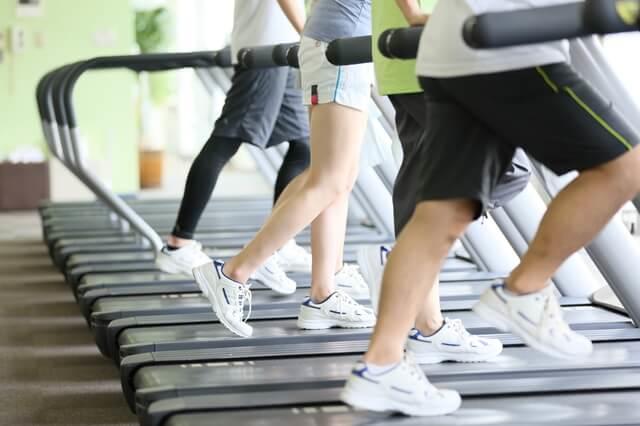 脂質異常症改善の運動療法の例としてトレーニングジムのランニングマシンでウォーキングしている写真。脂質異常症（高脂血症）は、偏った栄養バランスの食事や運動不足などの生活習慣から引き起こされていることが多く、脂質異常症を改善するには、食事療法と運動療法を基本とした生活習慣の改善を図ることが必要。