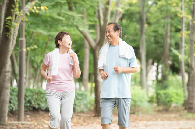 高齢者夫婦がジョギングしている写真。加齢に伴い成長ホルモン、女性ホルモンのエストロゲン、男性ホルモンのテストステロン、DHEAなどの分泌量が低下し、更年期障害など身体的に大きな影響を及ぼします。そのため、ホルモンを増やす方法として補充療法が用いられます。