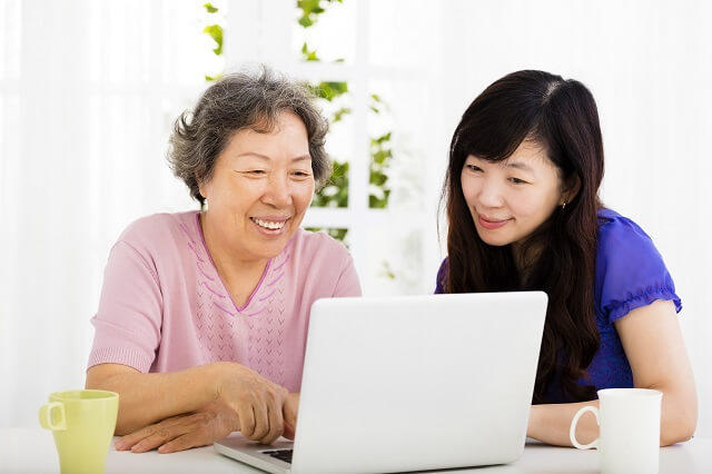 写真１：高齢女性と若い女性が一緒にノートパソコンをみている写真