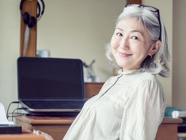 img1:笑顔の高齢女性が椅子に座っている写真