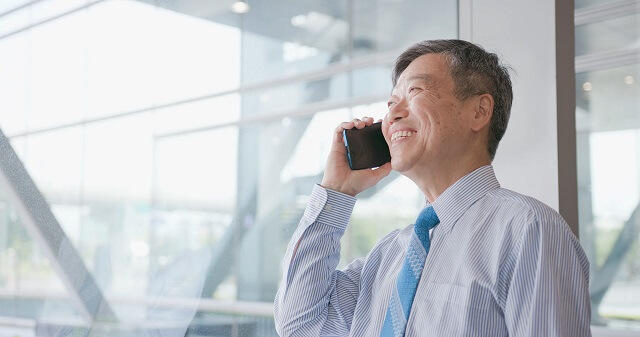 写真1：スマートフォンで電話する高齢男性