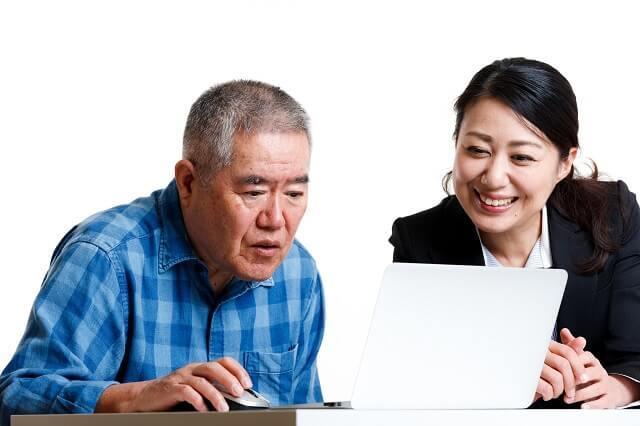 画像1:パソコンを教わる高齢男性の写真