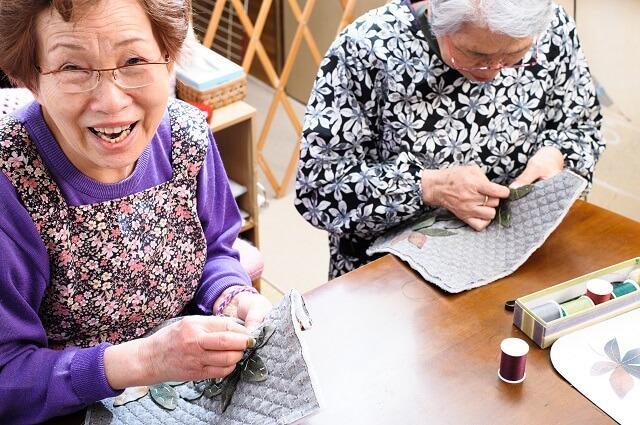 画像２：刺繍をする二人の高齢女性の写真