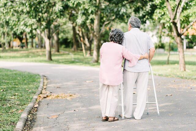 img：高齢の妻が夫を支えて歩いている写真