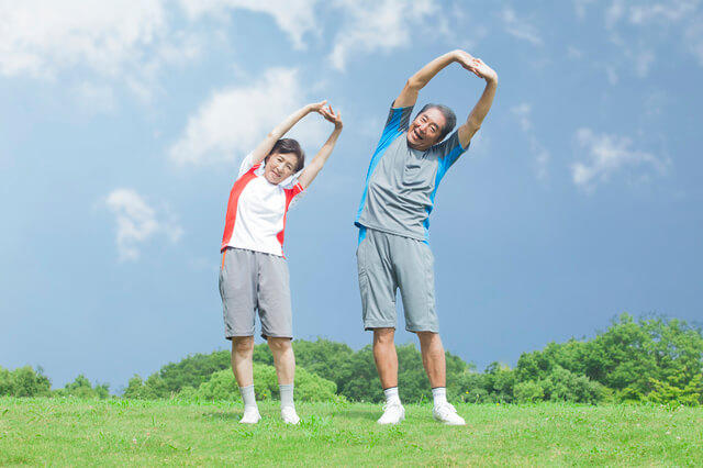 体操する高齢者夫婦の写真。厚生労働省による、健康づくりのための身体活動基準2013ではライフステージに応じた健康づくりと生活習慣病の重症化予防、運動だけではなく、生活上での身体活動の重要性に着目した内容になります。18～64歳の身体活動の基準は3メッツ以上の身体活動を週23メッツ時行います。