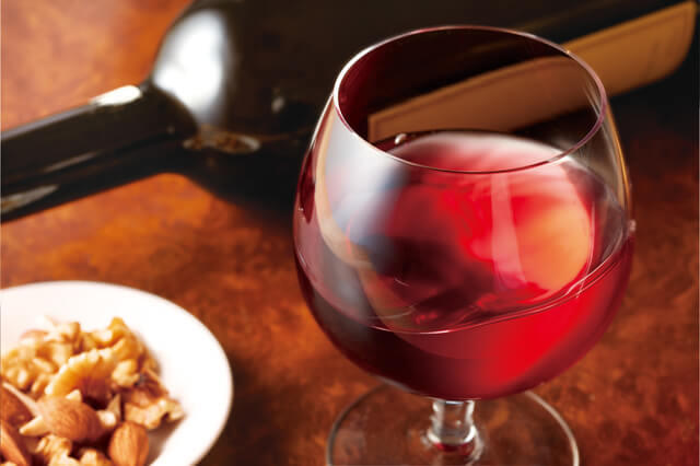 写真：グラスに入った赤ワインの写真。地中海食の特徴として食事と一緒に赤ワインを飲むことを示す。