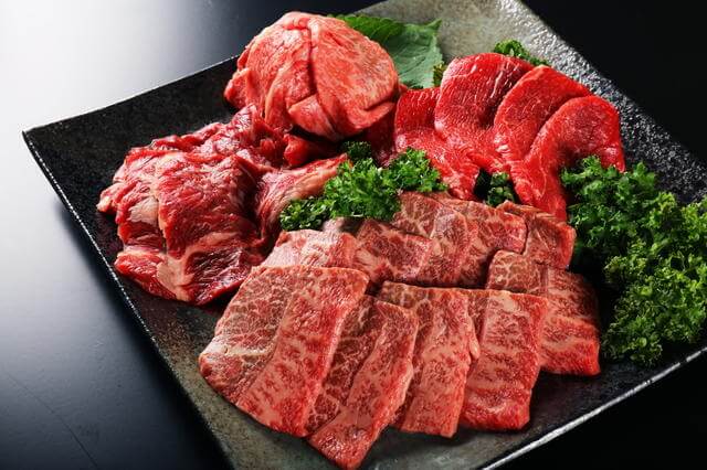 写真：黒い皿に牛肉の赤身肉をたくさん盛り付けた写真。長生きしている高齢者は肉を多めに食べていることを示唆させる