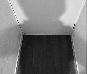 写真2:廊下の隅にできる身体の影を示す写真。身体より後方に照明がある場合、身体の影が床面にできることで段差を見分けにくくすることを表す。