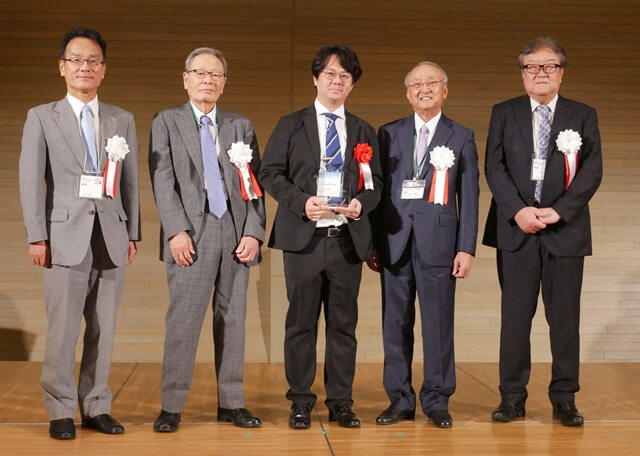 浜田将太氏の表彰式の様子を表す写真。