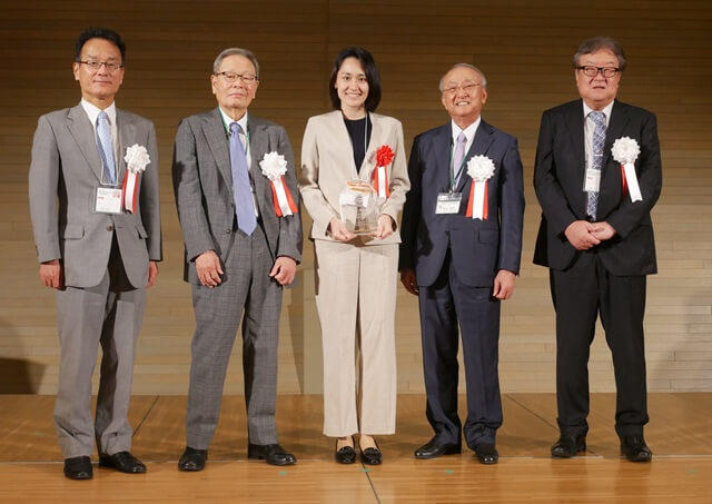 山口裕子氏の表彰式の様子を表す写真。